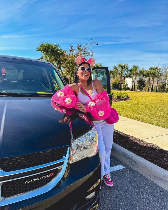 Evelyn Regly ao lado de uma Dodge Grand Caravan da AZ Car Rental