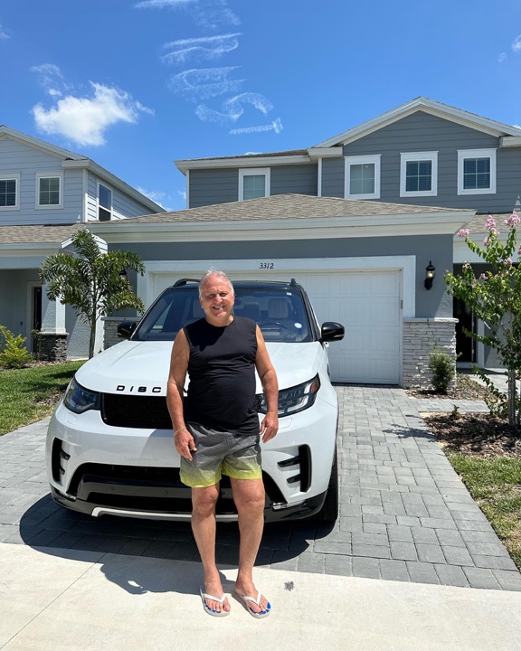Zico ao lado de um Land Rover Discovery da AZ Car Rental